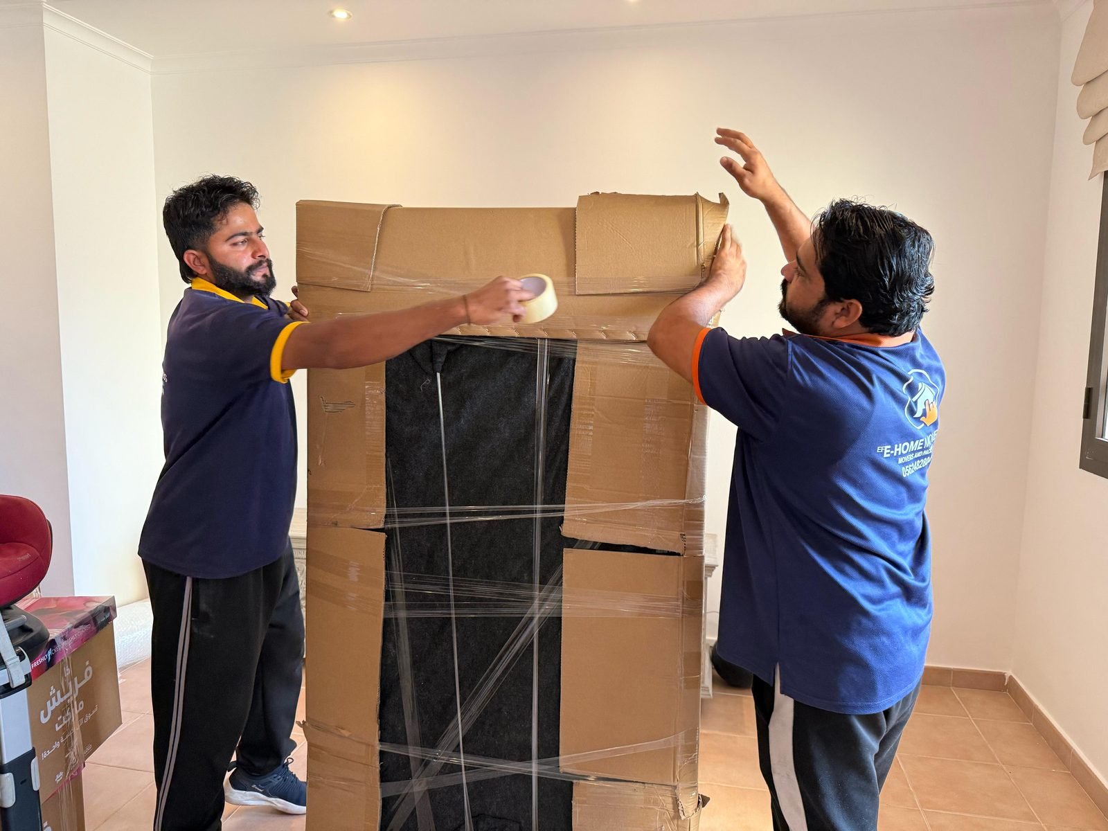 Best villa movers Dubai wrapping and taping tall furniture for transport